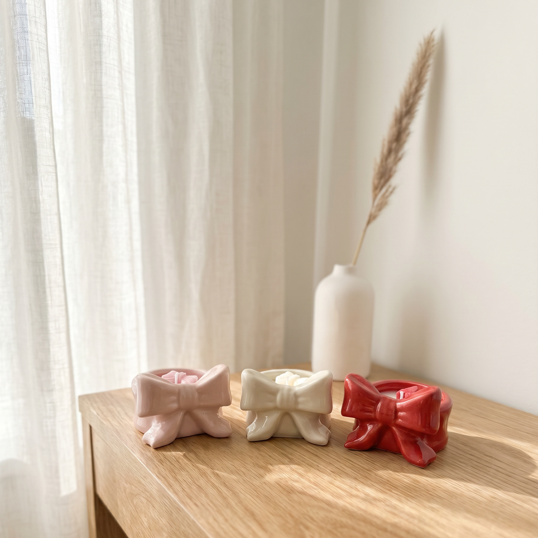Vela aromatica mini lacitos en ceramica con forma de lazo en colores blanco rosa y rojo elaborada a mano pieza a pieza
